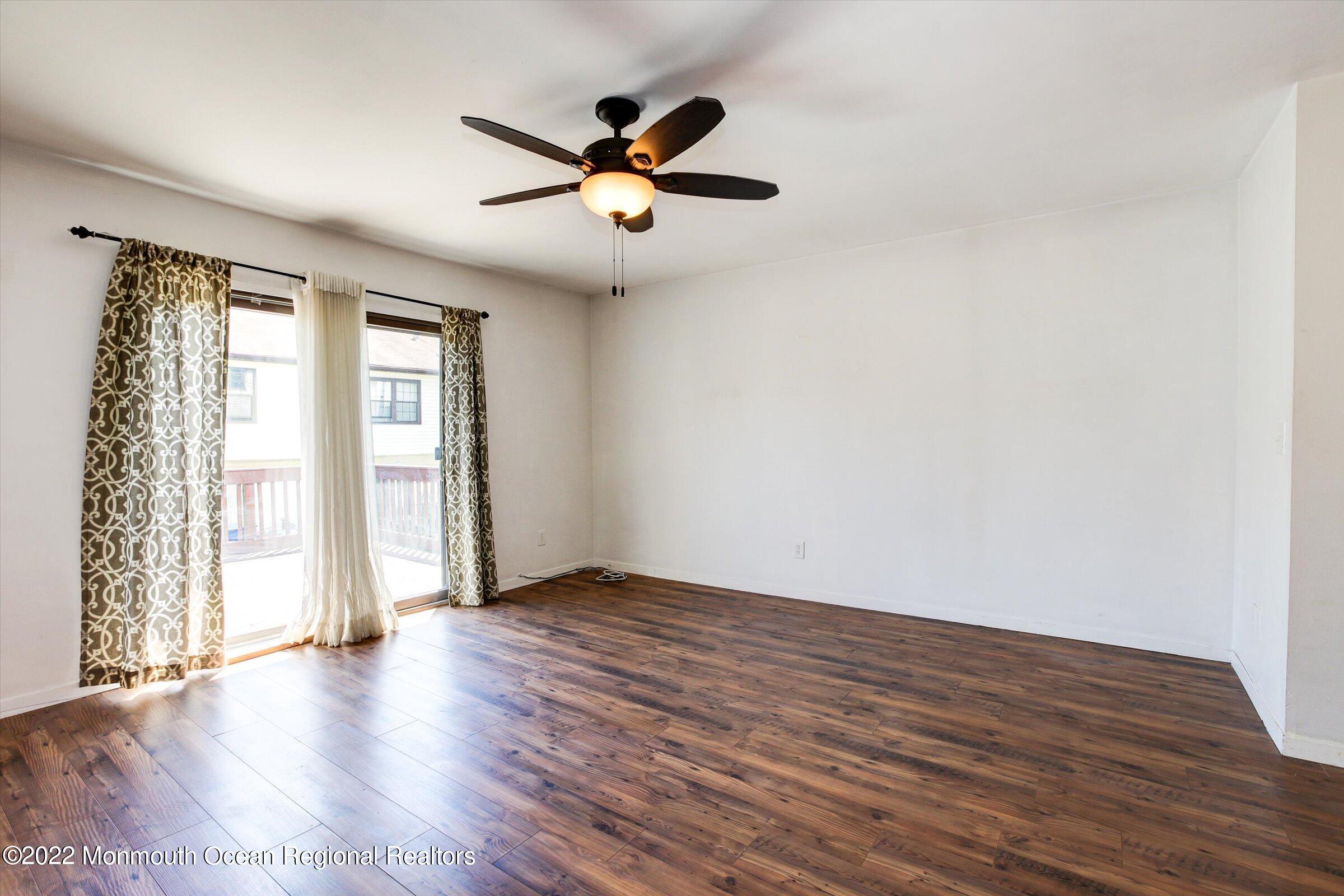 51 Queens Way Englishtown, NJ 07726 - Photo 13 of 25 an empty room with wooden floor fan and windows