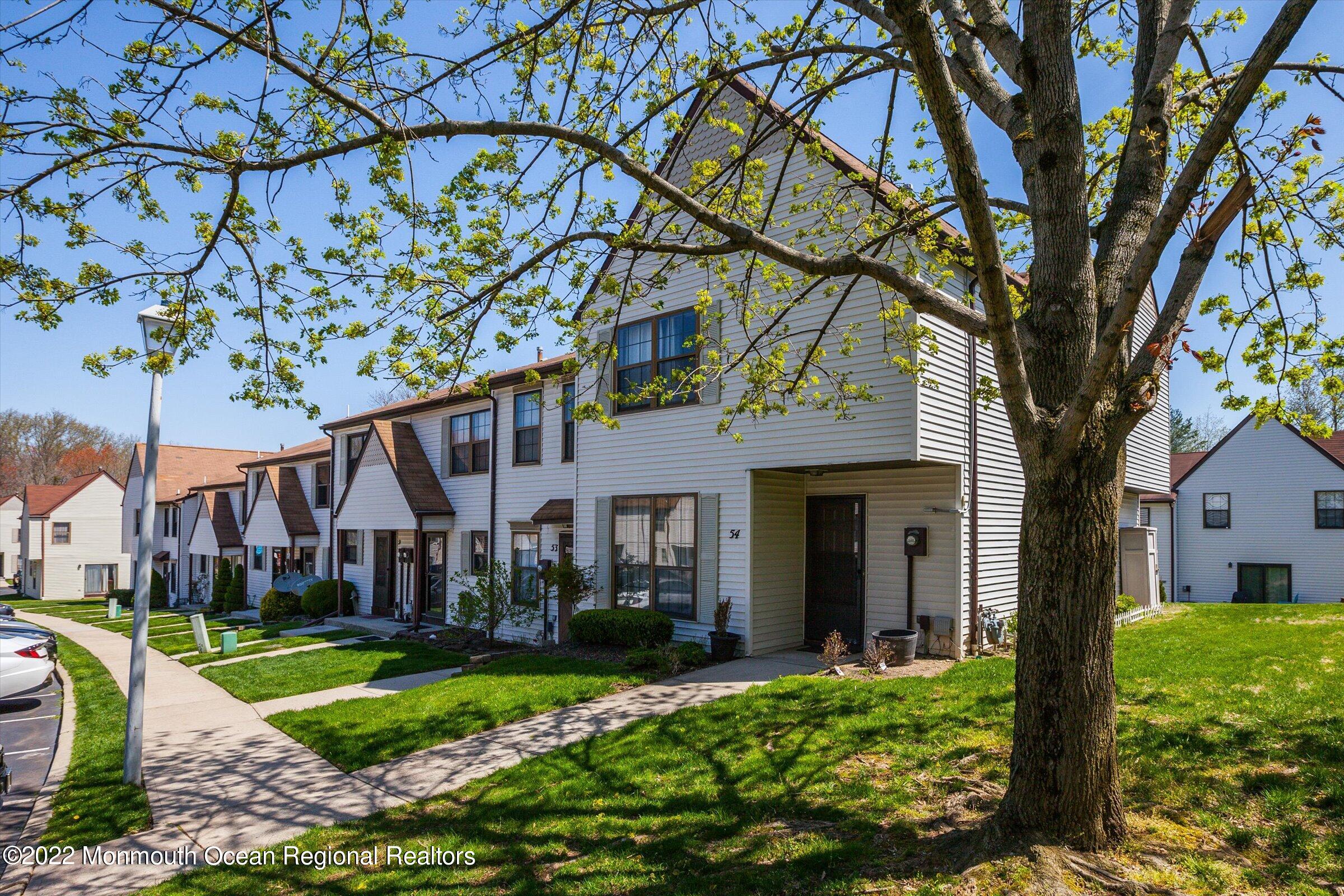 51 Queens Way Englishtown, NJ 07726 - Photo 2 of 25 a view of a white house next to a yard with big trees and plants