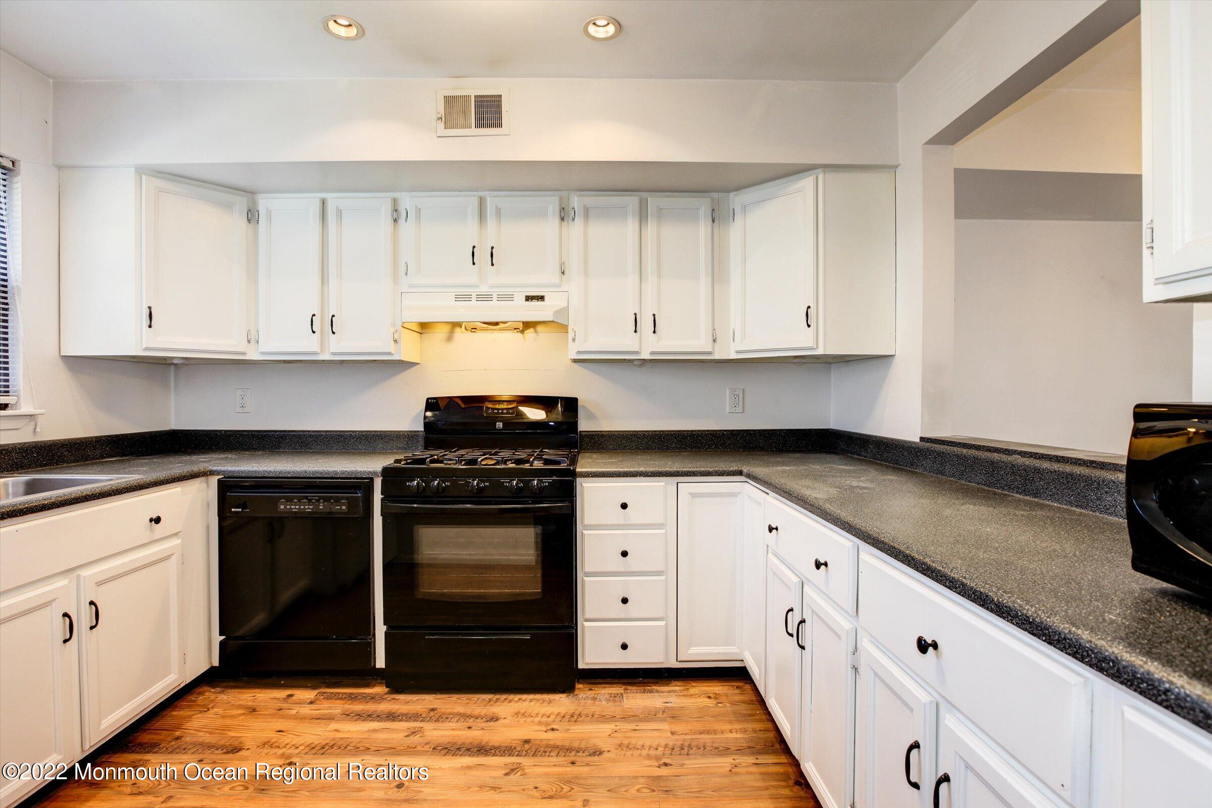 51 Queens Way Englishtown, NJ 07726 - Photo 3 of 25 a kitchen with granite countertop white cabinets and stainless steel appliances