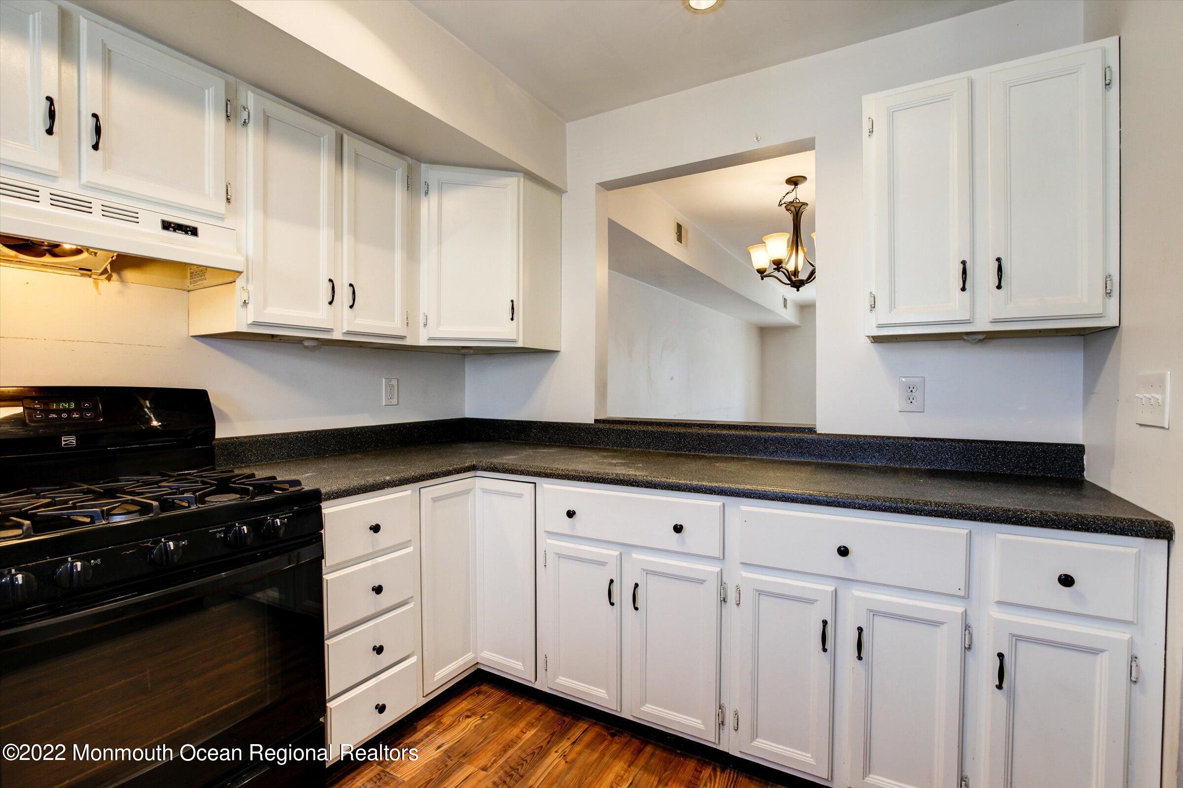 51 Queens Way Englishtown, NJ 07726 - Photo 6 of 25 a kitchen with granite countertop white cabinets and black appliances
