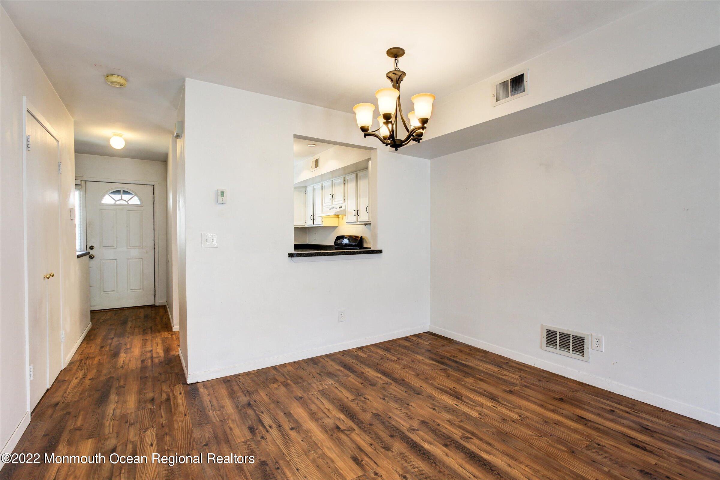 51 Queens Way Englishtown, NJ 07726 - Photo 9 of 25 a view of a room with wooden floor and chandelier