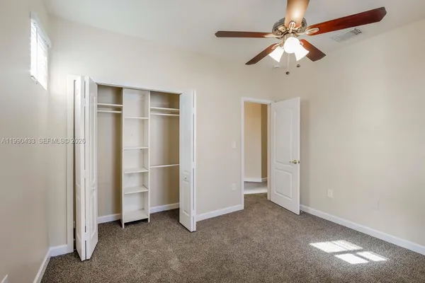 a view of empty room with ceiling fan