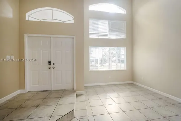 an empty room with cabinet and windows