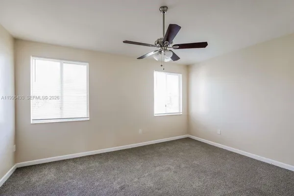 an empty room with a window and a fan