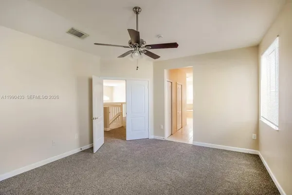 a view of a livingroom with a ceiling fan and window