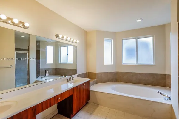 a bathroom with a large tub sink and vanity