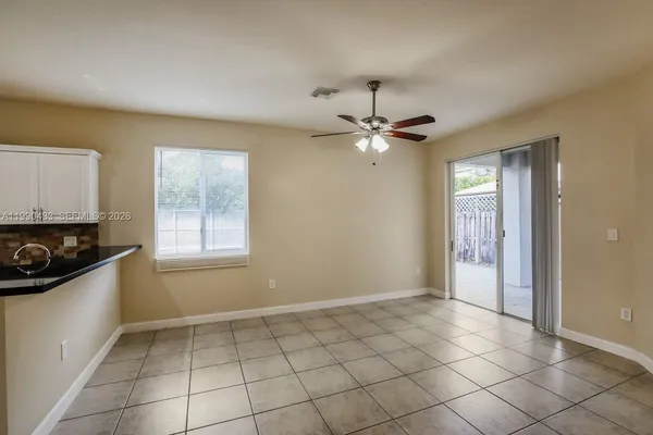 an empty room with windows and fan