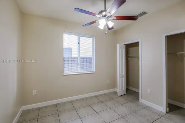 an empty room with fan and windows