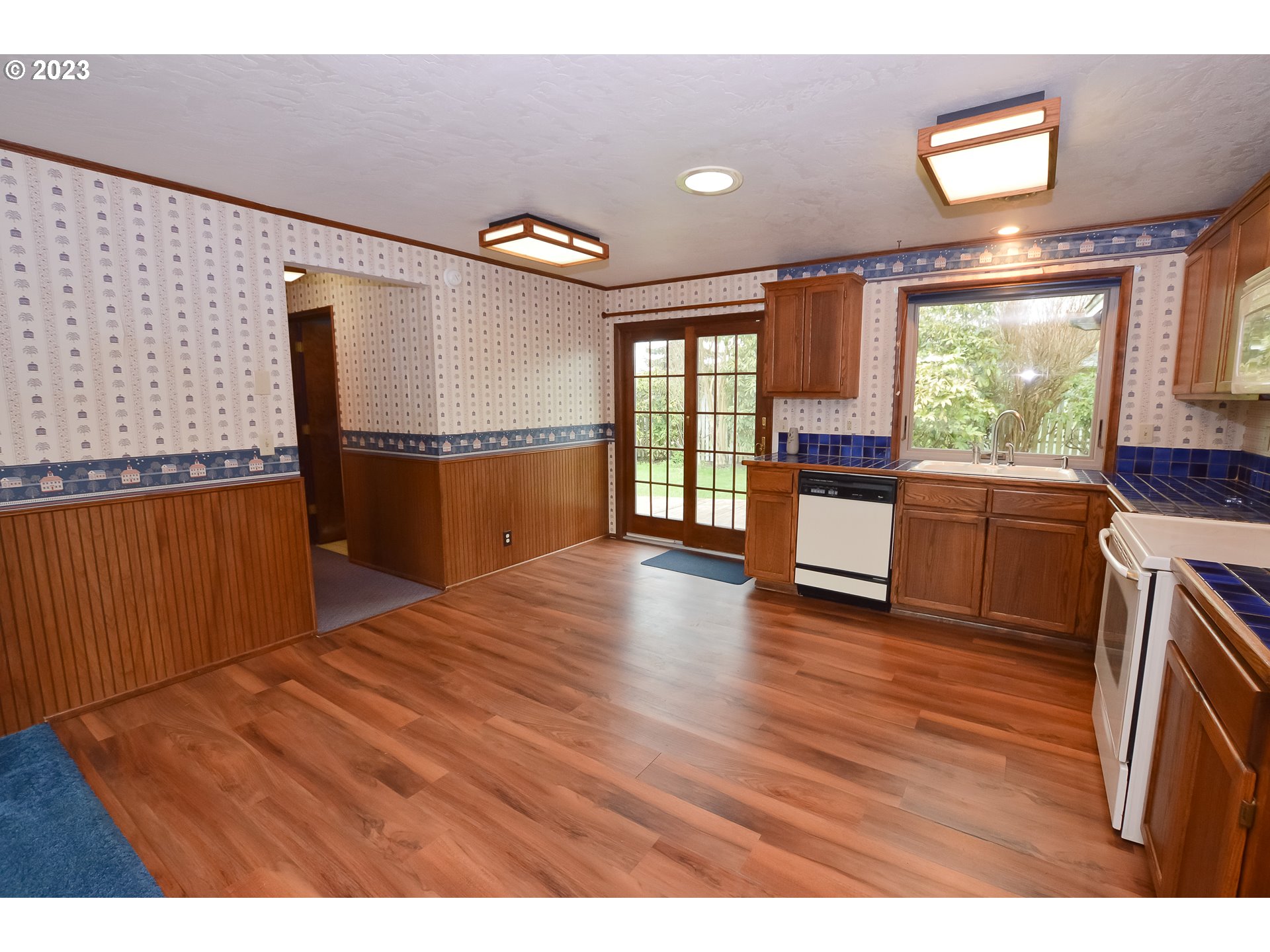 2470 16th Street Springfield, OR 97477 - Photo 11 of 32 a kitchen with stainless steel appliances granite countertop a refrigerator a sink dishwasher a stove and a dining table with wooden floor