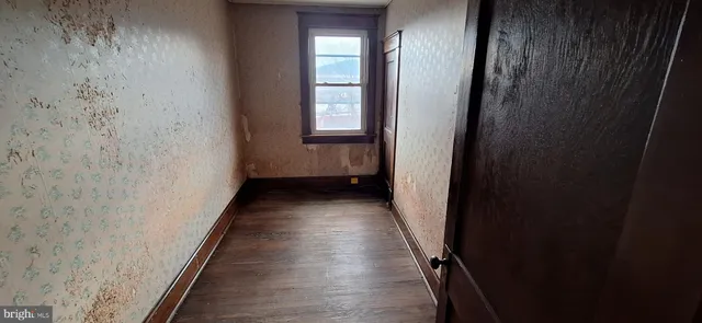 a view of a room with wooden floor and window