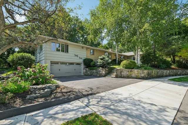 a front view of a house with a yard and potted plants
