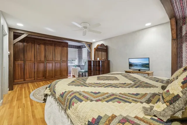 a bed sitting in a bedroom and wooden floor