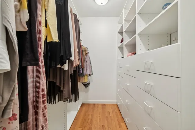 a view of walk in closet with clothes and shoes