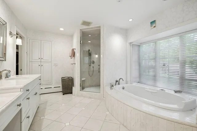 a spacious bathroom with a tub sink and mirror