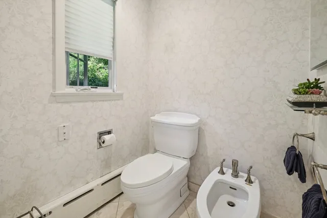 a white toilet sitting next to a bathroom sink and tub