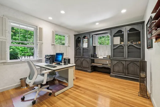 a view of a workspace with furniture and a window