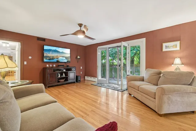 a living room with furniture flat screen tv and a large window