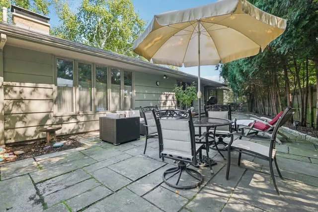 a view of a patio with table and chairs under an umbrella