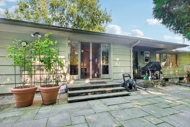 a view of a patio with table and chairs potted plants