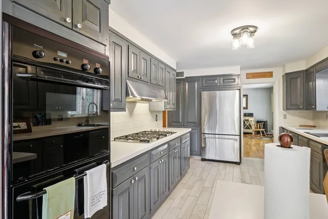 a kitchen with stainless steel appliances granite countertop a stove refrigerator sink and stove