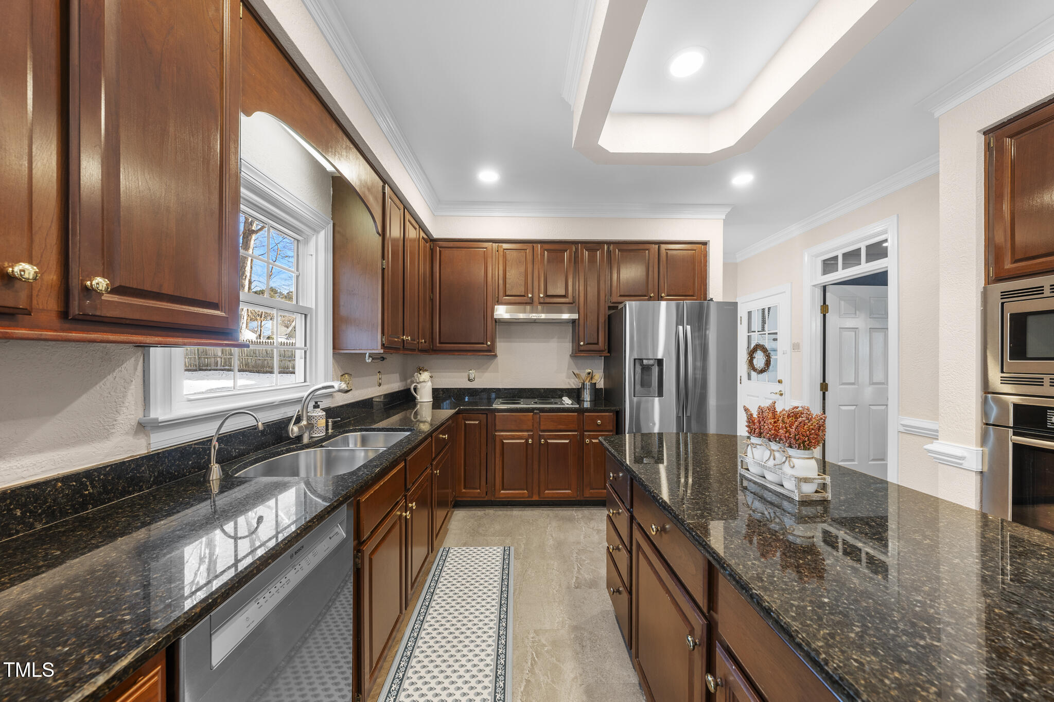 12016 Pembridge Lane Raleigh, NC 27613 - Photo 12 of 52 a kitchen with stainless steel appliances granite countertop wooden cabinets a stove a sink and a refrigerator