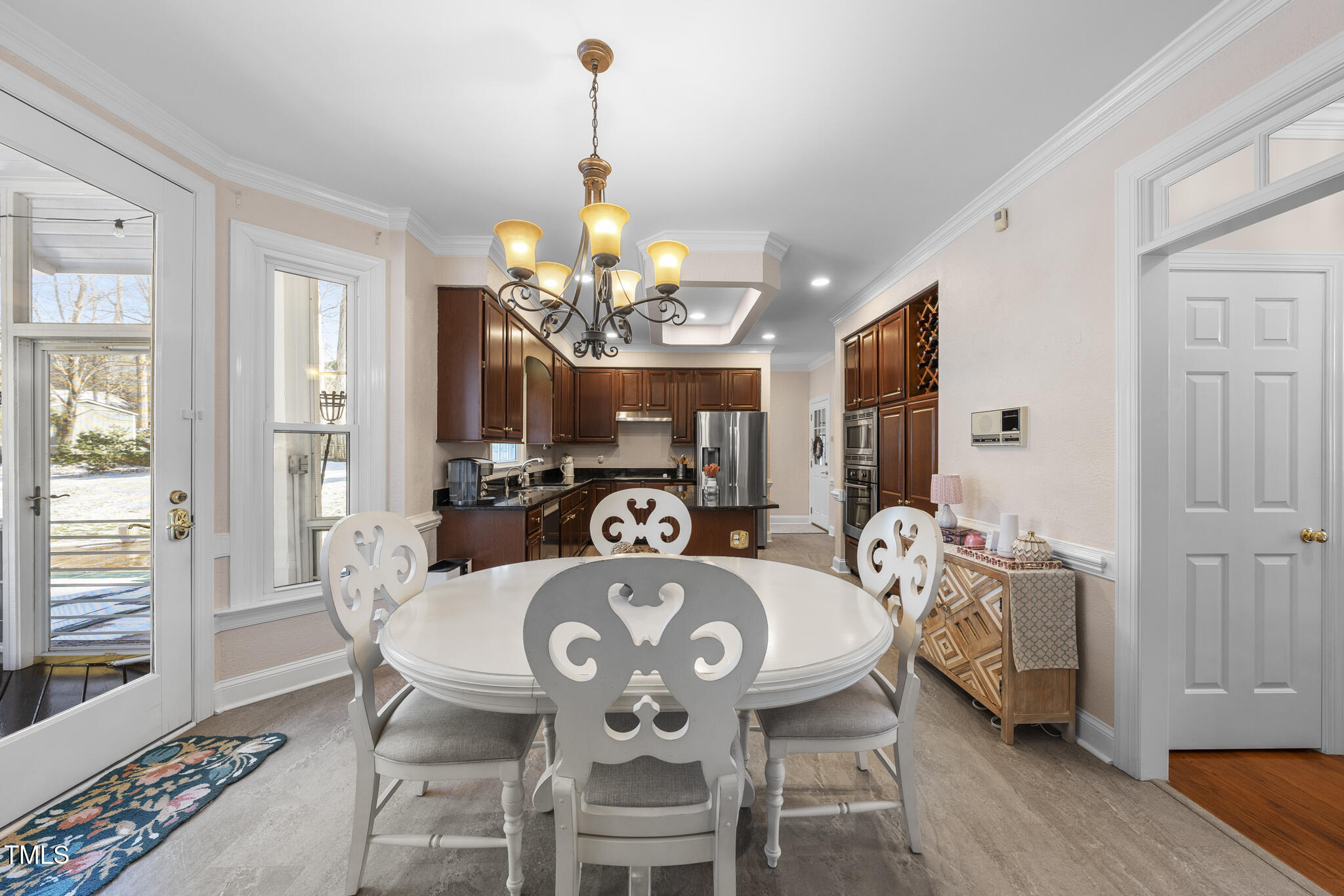 12016 Pembridge Lane Raleigh, NC 27613 - Photo 9 of 52 a view of a dining room with furniture a chandelier and wooden floor