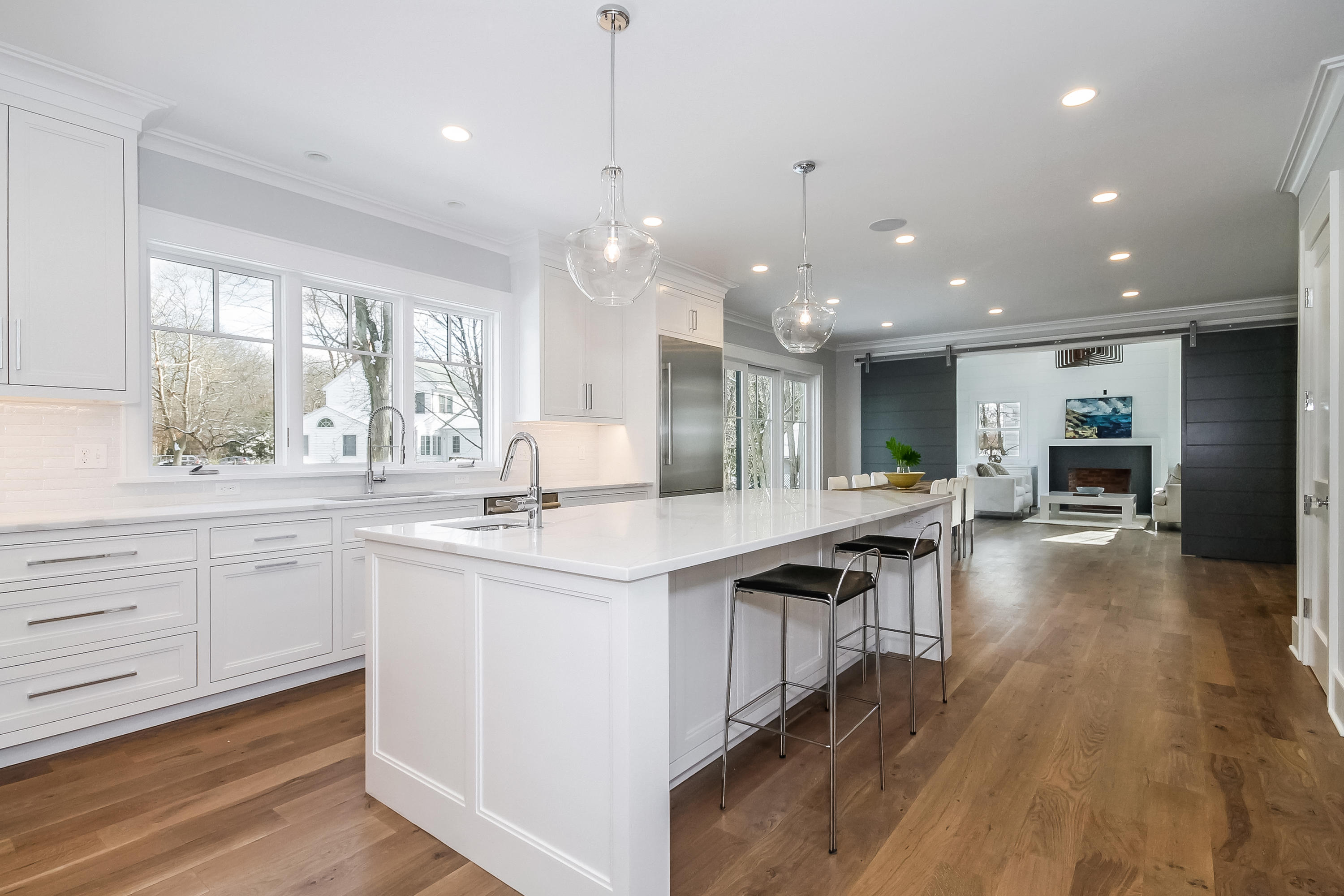 30 Relihan Road Darien, CT 06820 - Photo 8 of 47 a open kitchen with kitchen island a sink dishwasher a stove and a dining table with wooden floor