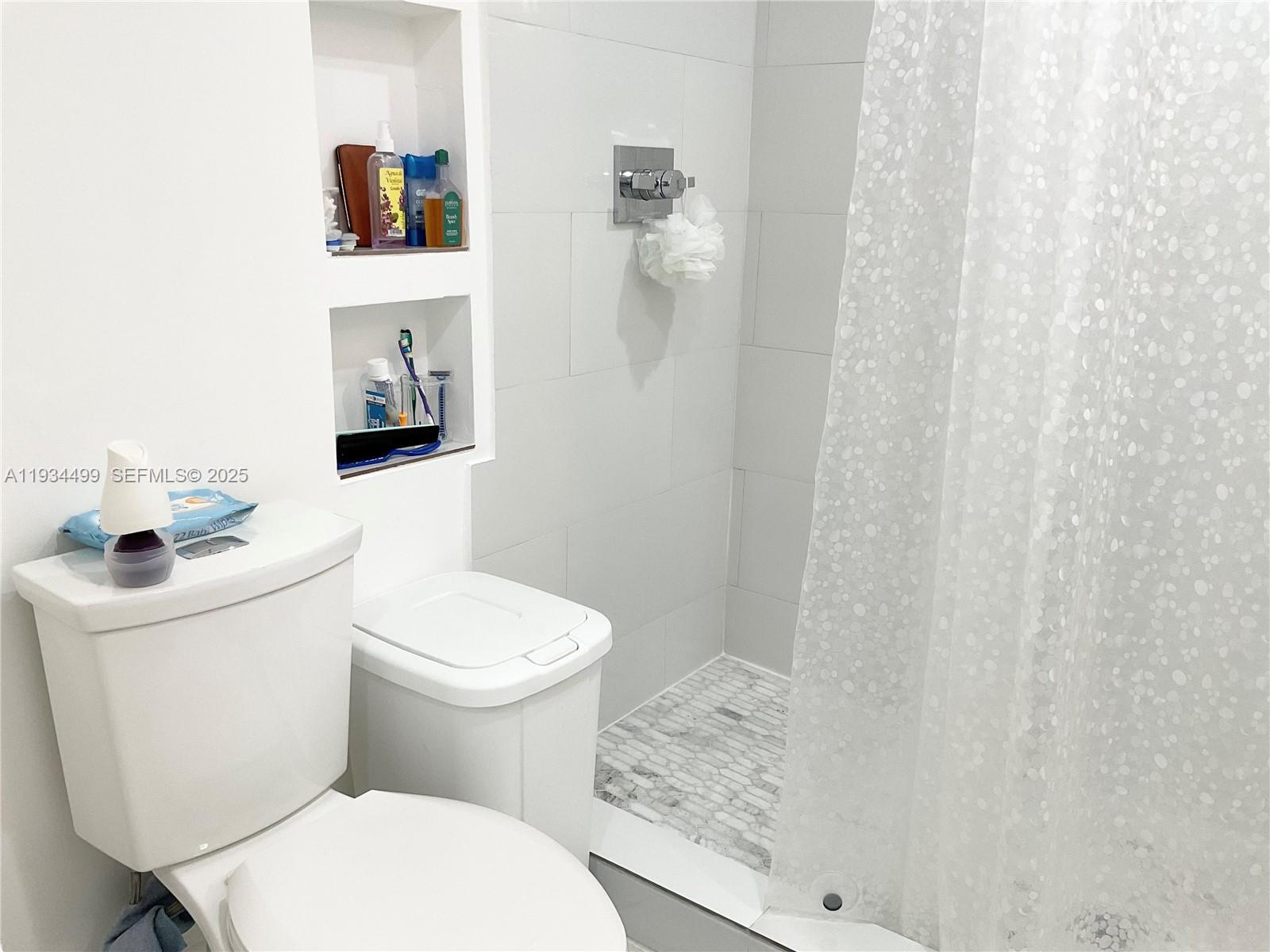 161 Northwest 145th Street Miami, FL 33168 - Photo 13 of 39 a white toilet sitting next to a bathroom sink