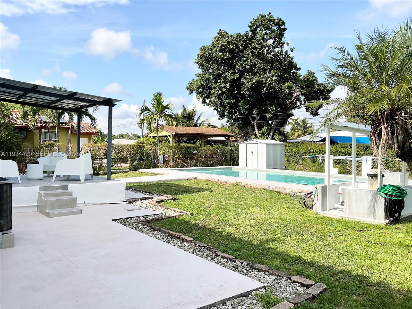 161 Northwest 145th Street Miami, FL 33168 - Photo 30 of 39 swimming pool view with a seating space and a garden view