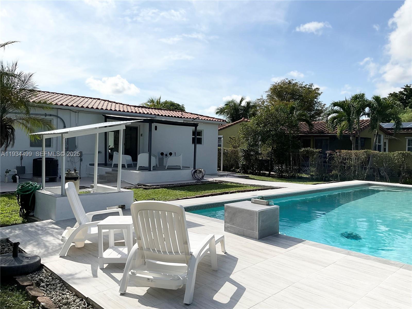 161 Northwest 145th Street Miami, FL 33168 - Photo 34 of 39 a view of a house with swimming pool and sitting area