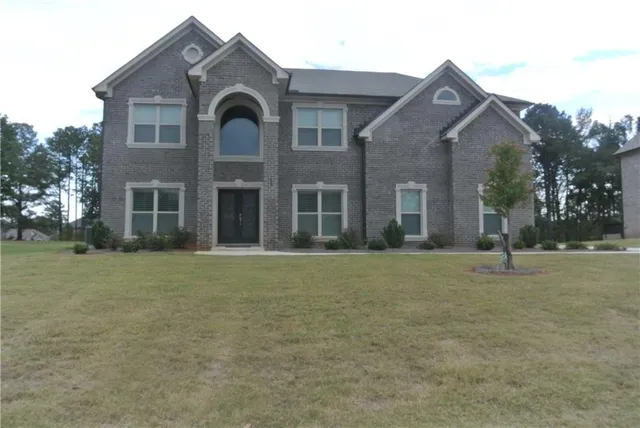 a front view of a house with a garden