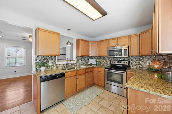 a kitchen with stainless steel appliances granite countertop a stove sink and microwave