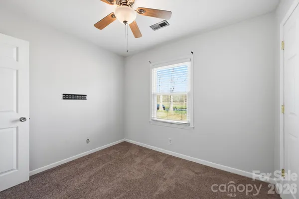 an empty room with a window and a ceiling fan