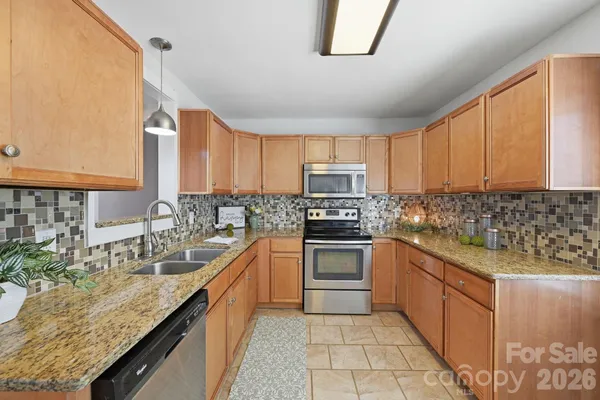 a kitchen with stainless steel appliances granite countertop a sink stove and cabinets