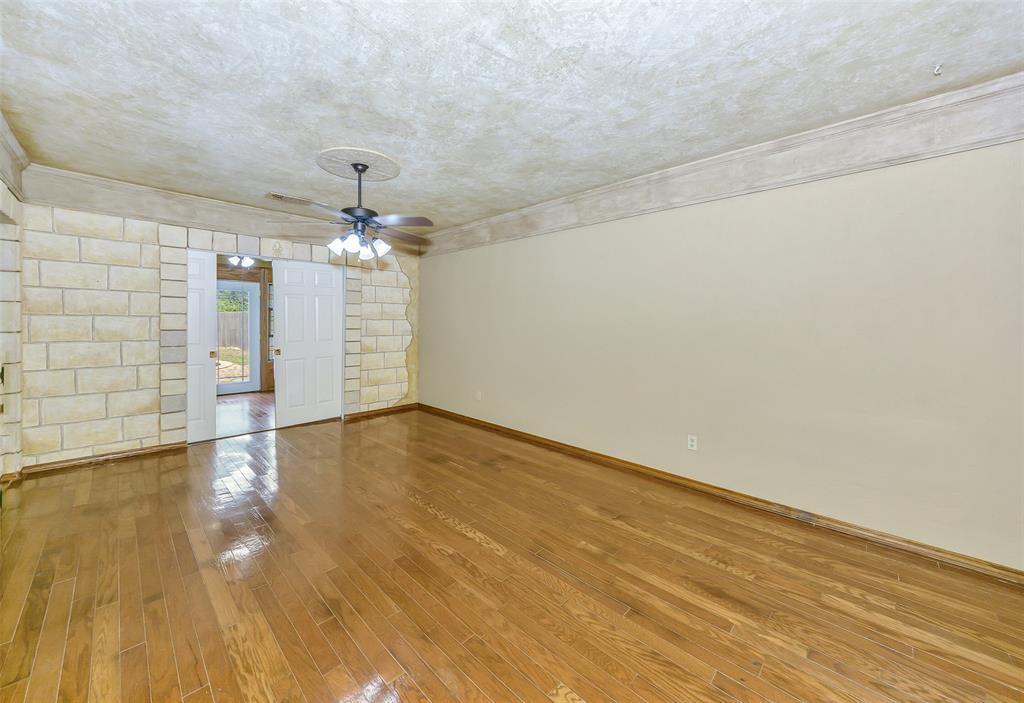 716 Bridget Way Hurst, TX 76054 - Photo 13 of 19 an empty room with wooden floor chandelier and windows