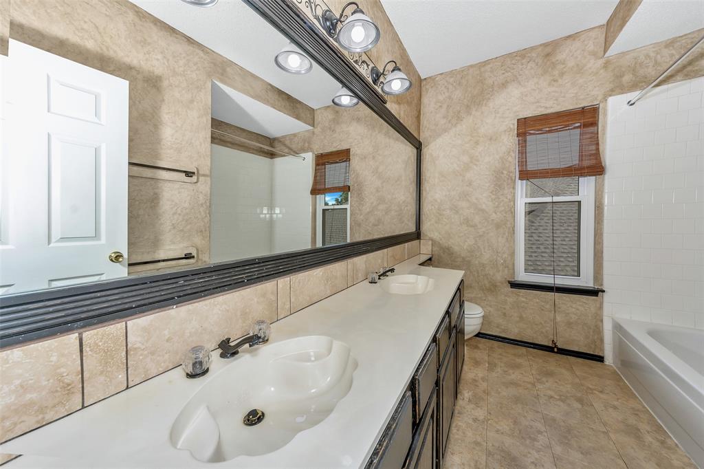 716 Bridget Way Hurst, TX 76054 - Photo 16 of 19 a bathroom with a double vanity sink a mirror and a bathtub