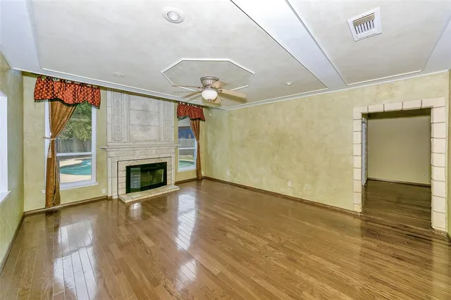 a view of empty room with wooden floor and fireplace