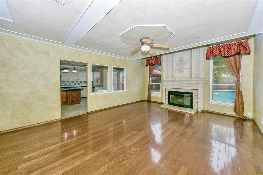 716 Bridget Way Hurst, TX 76054 - Photo 5 of 19 an empty room with wooden floor fireplace and windows