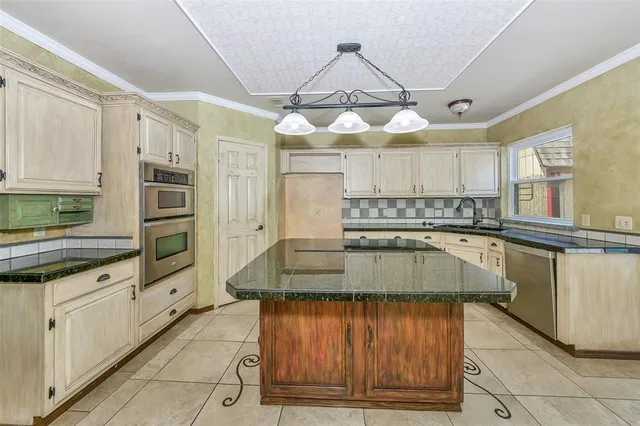 a kitchen with stainless steel appliances granite countertop a stove a sink and a refrigerator
