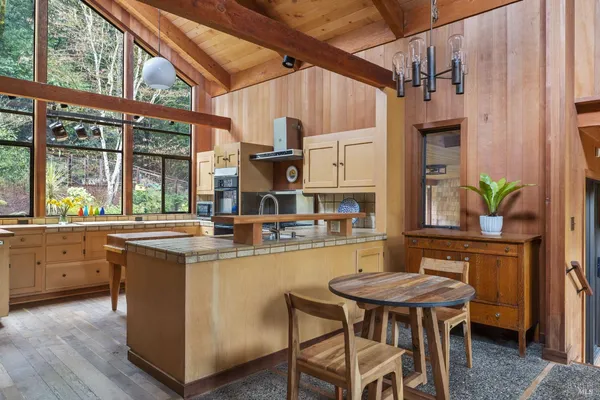 a kitchen with kitchen island a table and chairs in it
