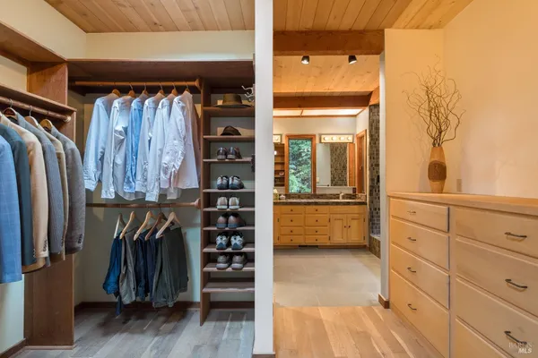 a view of walk in closet with clothes and shoes
