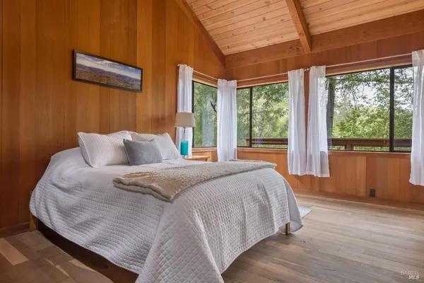 a bedroom with a bed and a large window