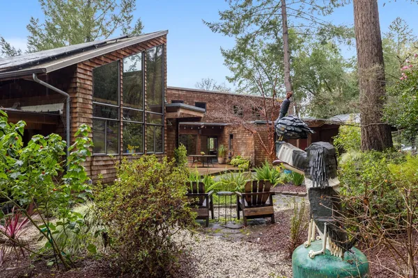a view of a chair and table in backyard of the house