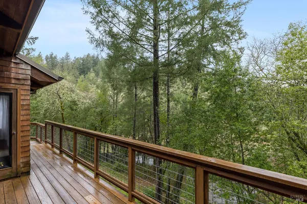 a view of a balcony with wooden stairs and trees