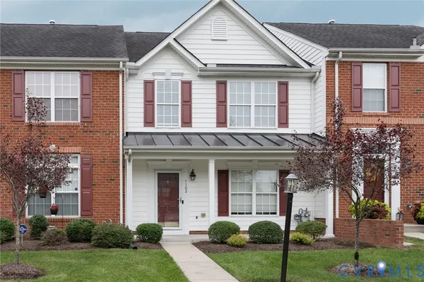 front view of a brick house with a yard