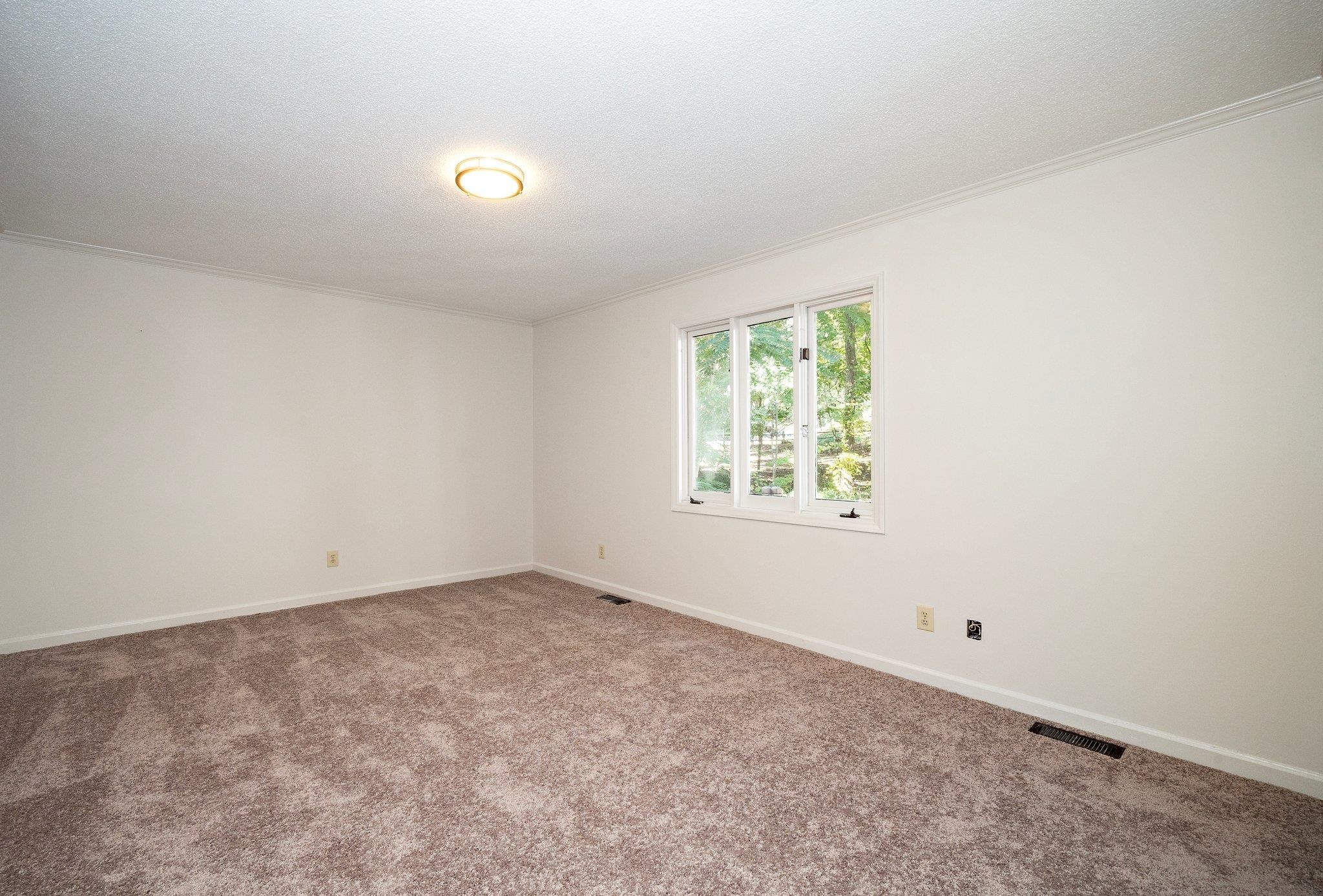 6304 Rushingbrook Drive Raleigh, NC 27612 - Photo 13 of 51 an empty room with windows