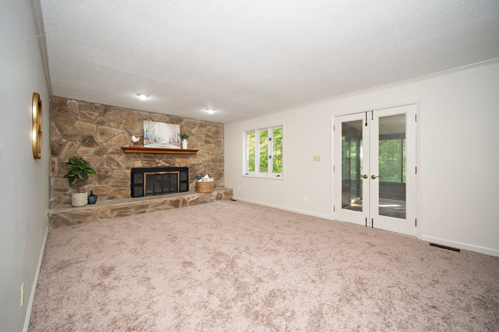 6304 Rushingbrook Drive Raleigh, NC 27612 - Photo 17 of 51 an empty room with furniture and a fireplace