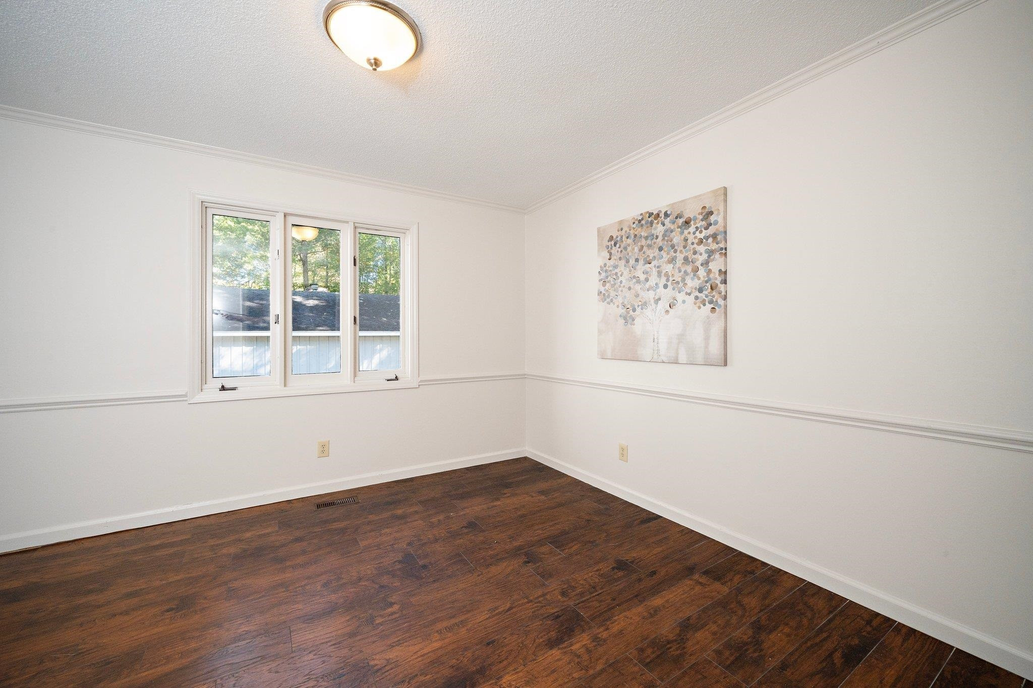 6304 Rushingbrook Drive Raleigh, NC 27612 - Photo 19 of 51 an empty room with wooden floor and windows