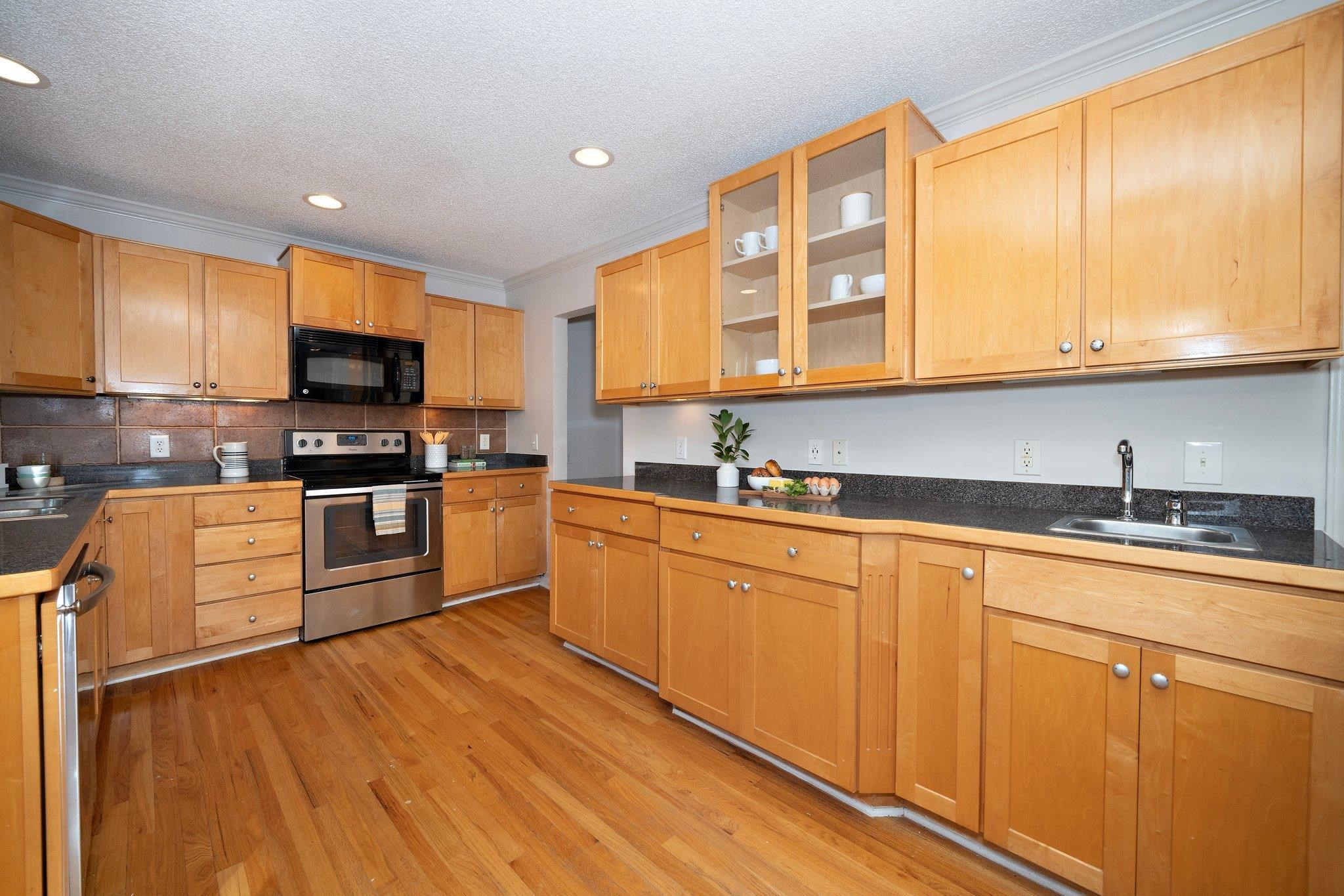 6304 Rushingbrook Drive Raleigh, NC 27612 - Photo 21 of 51 a kitchen with stainless steel appliances granite countertop a stove a sink and a microwave