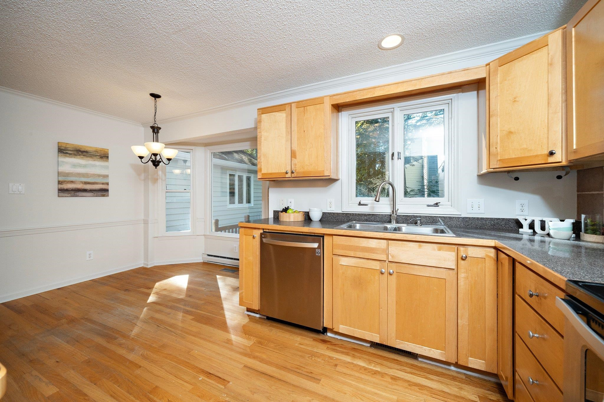 6304 Rushingbrook Drive Raleigh, NC 27612 - Photo 22 of 51 a kitchen with stainless steel appliances granite countertop a sink cabinets and a large window